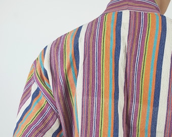 May include: A long-sleeved shirt with vertical stripes in shades of purple, orange, blue, green, and white.