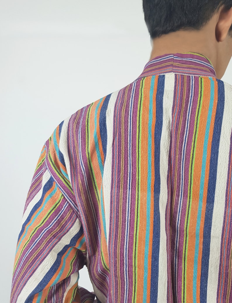 May include: A long-sleeved shirt with vertical stripes in shades of purple, orange, blue, green, and white.