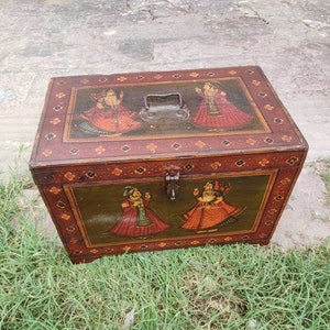 May include: A wooden storage box with a hinged lid and metal clasps. The box is decorated with hand-painted scenes of people in traditional clothing. The box is painted in shades of red, green, yellow, and brown.