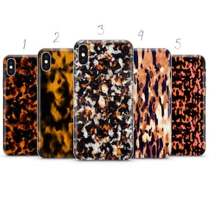 May include: Five different phone cases with a tortoiseshell pattern. The cases are all clear and show the pattern through the case. The patterns are all different shades of brown, orange, and black.
