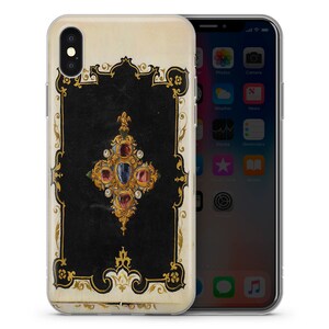 以下が含まれることがあります： ビンテージデザインの黒と金のiPhoneケース。宝石で飾られた十字架が特徴です。十字架は金でできており、赤、青、緑の宝石が飾られています。