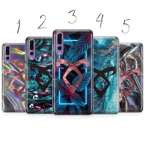 May include: Five different phone cases with a black and rose gold symbol on a variety of backgrounds. The backgrounds include iridescent, blue and green marble, tropical leaves, blue and green marble, and gold and black marble.