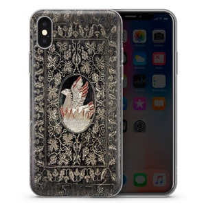 以下が含まれることがあります： 黒と金のiPhoneケース。フレームの中に鳥が描かれ、周りを花柄が囲んでいます。