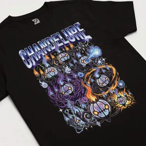 Może przedstawiać: Czarny t-shirt z kolorowym wzorem graficznym. Napis "CHANDELURE" jest w stylu 3D. Projekt zawiera stylizowane płomienie i duchopodobne postacie w odcieniach fioletu, pomarańczu i niebieskiego.