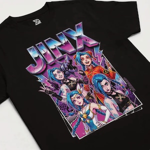 May include: Black t-shirt featuring a graphic of the word "JINX" in a stylized, colorful font with a purple and blue lightning bolt design. The graphic includes four cartoon characters with blue hair.