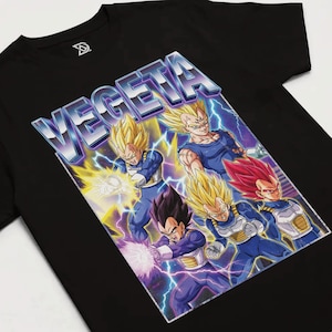 Puede incluir: Camiseta negra con un diseño del personaje Vegeta de Dragon Ball Z. El diseño incluye la palabra "VEGETA" en 3D, con múltiples imágenes de Vegeta en varias formas, rodeado de rayos.