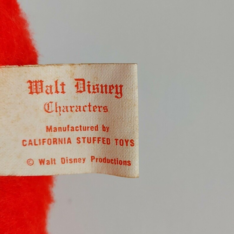May include: A white tag with red text that reads "Walt Disney Characters", "Manufactured by California Stuffed Toys", and "&copy; Walt Disney Productions".