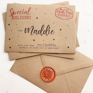 May include: A brown paper envelope with a red wax seal and a red stamp that says "North Pole Airmail Express Service". The envelope is addressed to "Maddie" and says "Special Delivery" with a star pattern. The text "With love from: Nana & Grandad Rose" and "Return to the North Pole if undelivered" is also on the envelope.