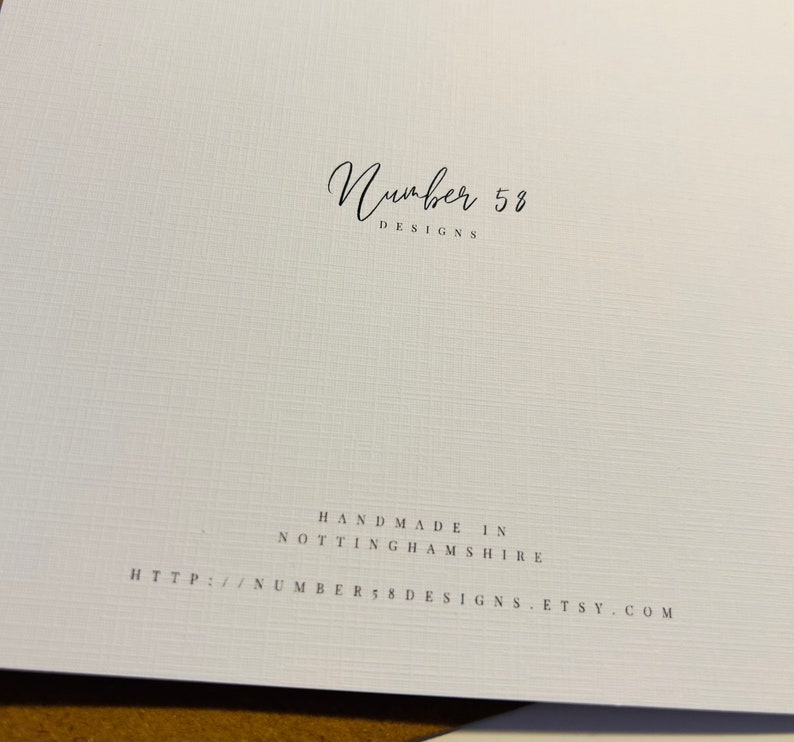 K&ouml;nnte beinhalten: Wei&szlig;e Karte mit schwarzem Text, der "Number 58 Designs" und "Handmade in Nottinghamshire" lautet, gefolgt von einer Website-Adresse: "http://number58designs.etsy.com".