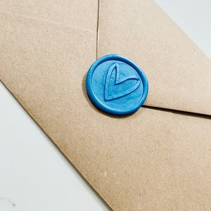 May include: A brown paper envelope with a blue wax seal featuring a heart design.