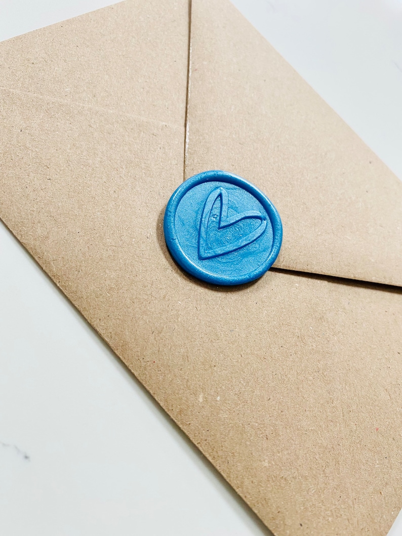 May include: A brown paper envelope with a blue wax seal featuring a heart design.