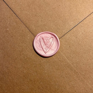 May include: A pink wax seal with a heart design.