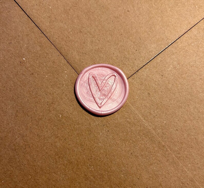 May include: A pink wax seal with a heart design.