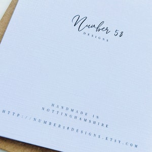 Puede incluir: Una tarjeta blanca con el texto "Number 58 Designs" en escritura cursiva negra. El texto "Handmade in Nottinghamshire" y la direcci&oacute;n del sitio web "http://number58designs.etsy.com" est&aacute;n impresos en negro debajo del logotipo.