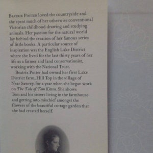 Puede incluir: Foto en blanco y negro de Beatrix Potter, la autora de la serie de libros infantiles "La historia de Peter Rabbit". La foto muestra a Potter con un vestido oscuro con un cuello blanco. El texto "www.peterrabbit.com" y "F. WARNE & Co" es visible debajo de la foto.