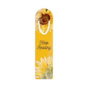 Puede incluir: Marcapáginas amarillo con un diseño de girasol y el texto "Keep Reading".