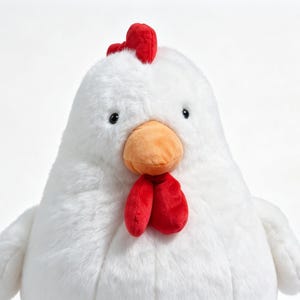 May include: A plush chicken toy featuring soft white fur, a bright orange beak, a vibrant red comb on top of its head, and two red wattles hanging below the beak. The stuffed animal has small black eyes and a rounded, plump body shape.