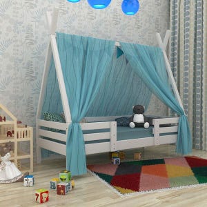 May include: A white wooden children's bed with a canopy of light blue fabric. The bed has a mattress and a small teddy bear. Colorful blocks and a geometric rug are in front of the bed.