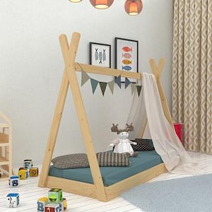 May include: A wooden teepee bed frame with a light blue mattress and a white canopy. The bed frame is decorated with a string of colorful flags.