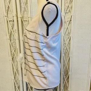 May include: Pale pink sleeveless top with black horizontal lines on the left side. The top has a scoop neck and a flowing, lightweight design. The fabric appears to be a soft, silky material.