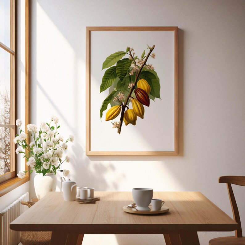 May include: A framed botanical print featuring a detailed illustration of a cacao branch with green leaves, yellow and brown pods, and small white flowers. The print is in a light wood frame, displayed in a well-lit room.