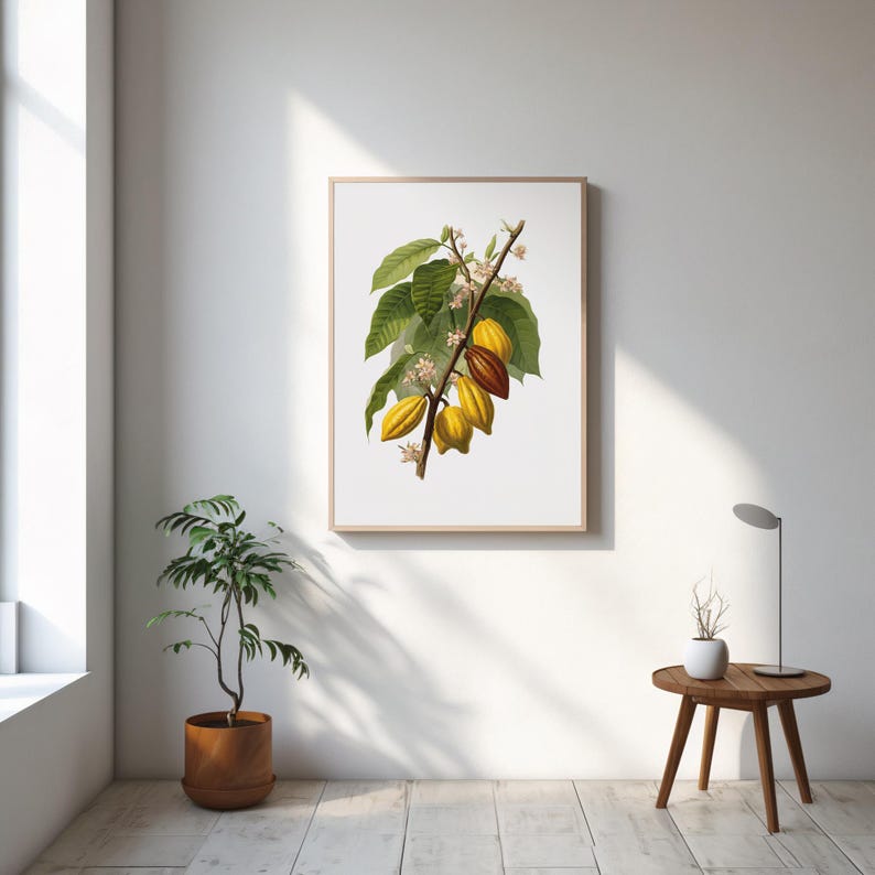 May include: A framed botanical print featuring a detailed illustration of a cacao plant branch. The artwork showcases green leaves, yellow and brown cacao pods, and delicate white flowers. The print is displayed on a white wall, adding a touch of nature-inspired decor.
