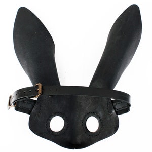 Peut inclure: Masque de lapin en cuir noir avec une sangle et deux trous pour les yeux.