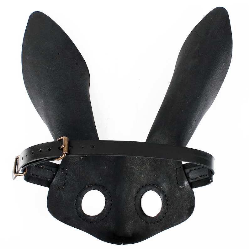 Peut inclure: Masque de lapin en cuir noir avec une sangle et deux trous pour les yeux.