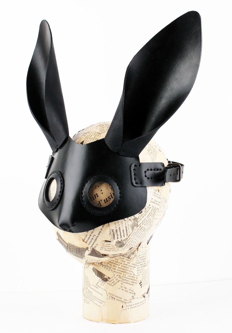 Peut inclure: Masque de lapin en cuir noir avec de grandes oreilles et deux trous ronds pour les yeux. Le masque est dot&eacute; d'une sangle pour le fixer &agrave; la t&ecirc;te.