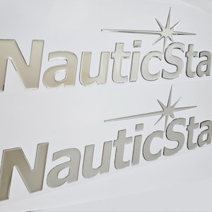May include: Two silver NauticStar logos with a starburst design. The logos are on a white background.