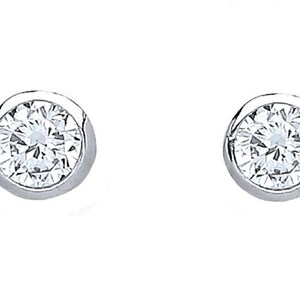 Op de afbeelding: Een paar ronde diamantstud-oorbellen met bezel-zetting. Elke oorbel heeft een sprankelende, heldere diamant gezet in een gepolijst, zilverkleurig metaal. De oorbellen worden gepresenteerd tegen een effen witte achtergrond.