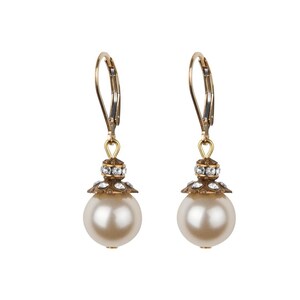 May include: A pair of gold dangle earrings with a white pearl and crystal accents.