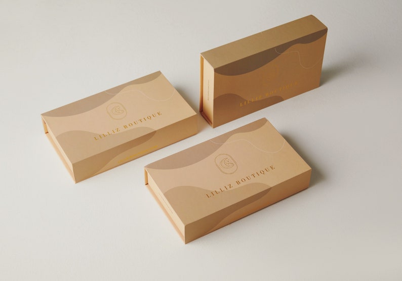 Op de afbeelding: Drie dozen met een beige achtergrond en gouden accenten. De dozen hebben een golvend ontwerp en de tekst "LILLIZ BOUTIQUE" staat op de voorkant.