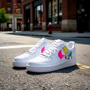Puede incluir: Zapatillas de cuero blanco con detalles rosas y un dibujo animado de Bart Simpson. Los zapatos tienen cordones y suelas blancas, y se muestran en una calle.