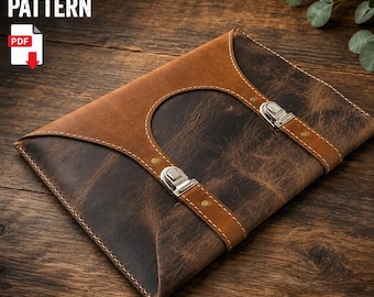 May include: A two-tone leather portfolio case featuring a dark brown distressed leather body and a lighter tan leather flap. The case includes two vertical leather straps secured with silver-toned metal buckles and visible stitching.