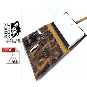 May include: A brown leather notebook cover with multiple pockets and a strap. The cover is open to reveal a blank notebook with a black spine. The notebook cover has a distressed look and is made of high-quality leather.