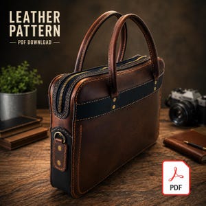 Peut inclure: Une mallette en cuir marron avec des accents noirs, deux poignées supérieures et une fermeture éclair. Le sac présente des coutures visibles, des rivets couleur laiton et un anneau en D latéral. Le texte indique LEATHER PATTERN PDF DOWNLOAD.