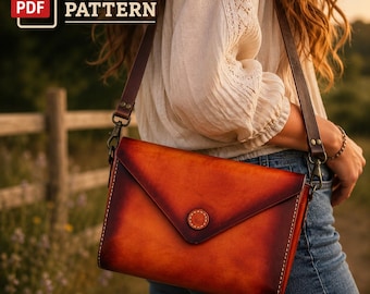 May include: A rectangular leather shoulder bag with a gradient orange and dark brown finish, featuring an envelope-style flap with a central circular button closure, visible white stitching along the edges, and a dark brown leather strap.