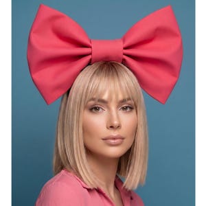 Red hair bow headband, bold festival accessory, rave outfit detail, bright party headwear, statement party piece