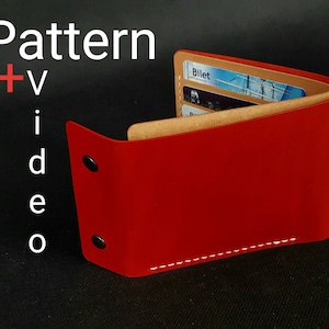 May include: A red leather wallet with a brown leather interior and a white stitch detail. The wallet is closed and has a card slot that says "Billet".