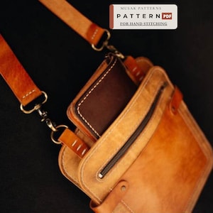 May include: A tan leather crossbody bag with a detachable strap, featuring a dark brown leather wallet tucked into the main compartment and a zippered front pocket. A label reads MUSAK PATTERNS PATTERN PDF FOR HAND STITCHING.