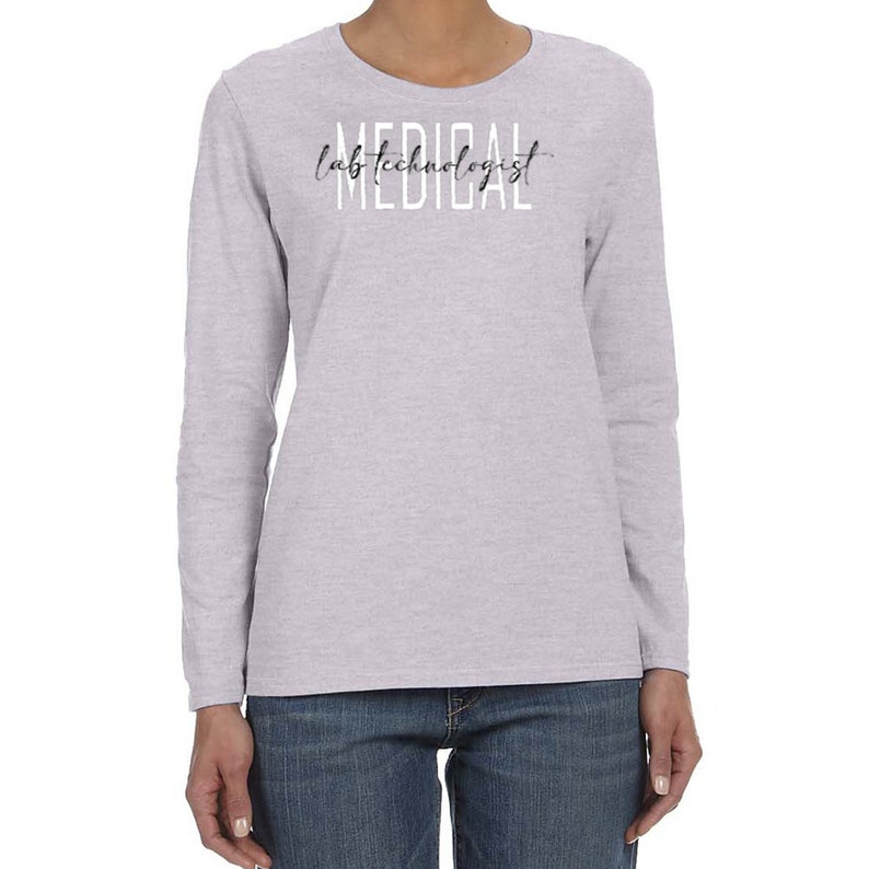 May include: A heather grey long-sleeve t-shirt with the text "lab technologist" written in black script above the word "MEDICAL" in white letters.