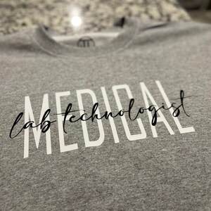 May include: Gray sweatshirt with the text "MEDICAL lab technologist" printed in white.