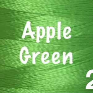 K&ouml;nnte beinhalten: Eine Spule mit Apfelgr&uuml;nem Stickgarn mit dem Aufdruck "Apple Green 20" auf der Seite.
