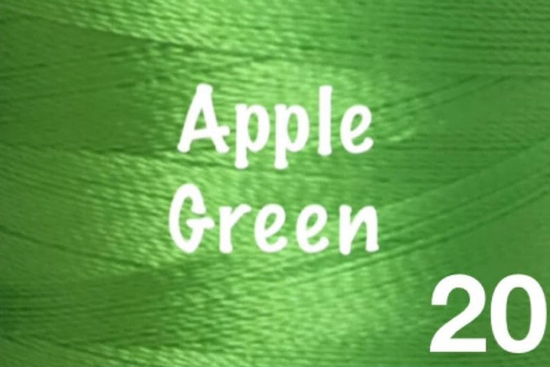 K&ouml;nnte beinhalten: Eine Spule mit Apfelgr&uuml;nem Stickgarn mit dem Aufdruck "Apple Green 20" auf der Seite.