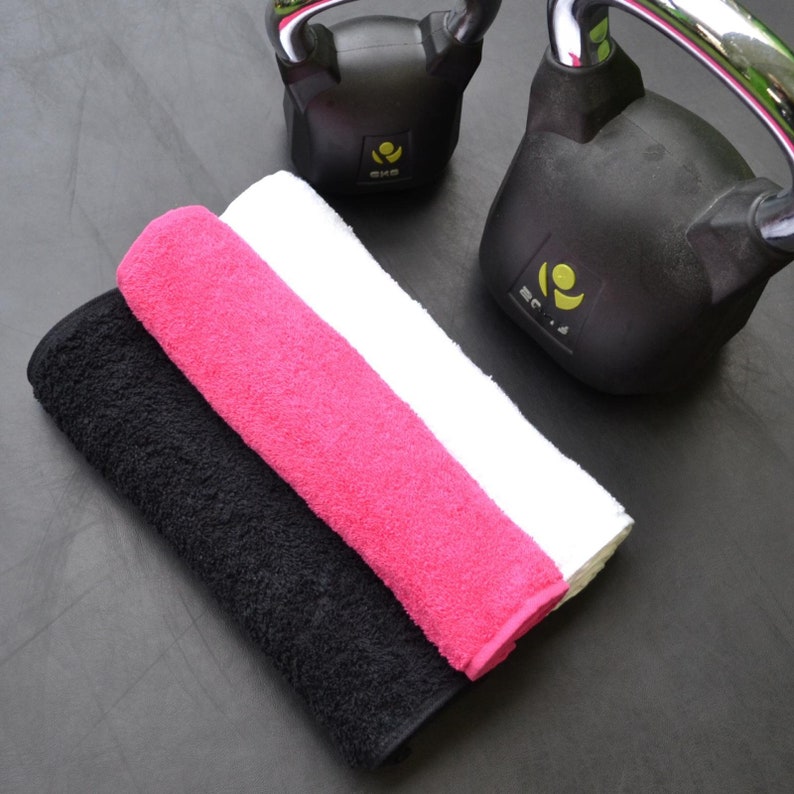 K&ouml;nnte beinhalten: Drei Handt&uuml;cher, eines schwarz, eines wei&szlig; und eines rosa, liegen &uuml;bereinander. Die Handt&uuml;cher bestehen aus einem weichen, saugf&auml;higen Material.