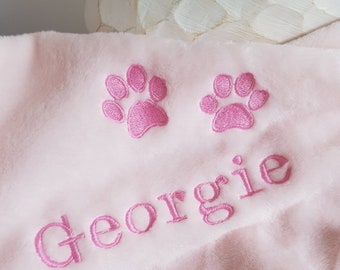May include: Pink plush blanket with two pink embroidered paw prints and the name "Georgie" embroidered in pink.
