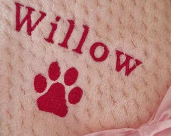 May include: Pink plush blanket with the name "Willow" and a red paw print embroidered on it.