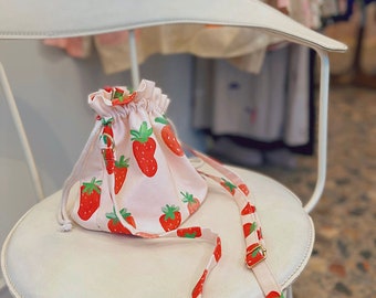Le sac Elsa unique et charmant avec l'imprimé emblématique fraise, parfait pour un style de soirée ainsi qu'une tenue sportive de tous les jours