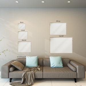 May include: A display of framed art prints in various sizes, including 8x10, 12x16, 16x20, 18x24, and 24x36 inches, mounted on a neutral-toned wall. A gray sofa with light blue pillows and a patterned throw is in the foreground.